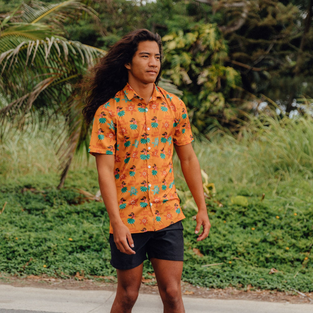 man walking with yellow button up shirt with hula print all over it on