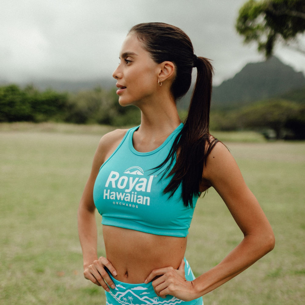 woman wearing blue yoga top with royall hawaiian logo